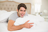 Close up portrait of a cheerful man resting in bed
