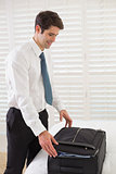 Businessman unpacking luggage at a hotel bedroom