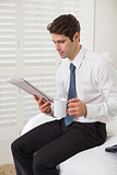 Businessman with coffee cup and newspaper at a hotel room