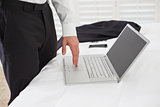 Mid section of businessman using laptop at hotel room