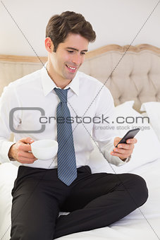 Well dressed man text messaging in bed