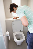 Man with stomach sickness about to vomit into the toilet