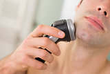 Extreme Close up of man shaving with electric razor