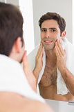 Rear view of a man looking at self in bathroom mirror