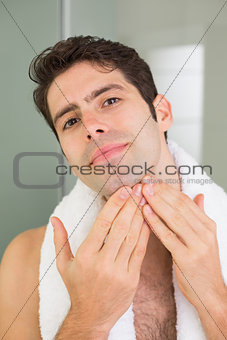 Handsome young man touching his face