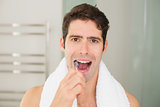Close up portrait of young man brushing teeth