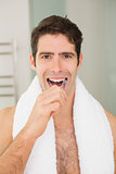 Young man brushing teeth in the bathroom