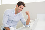 Cheerful man using laptop at home