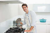 Portrait of a smiling man preparing food in kitchen