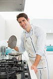 Smiling young man preparing food in kitchen