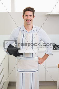 Smiling man holding a baking dish in kitchen