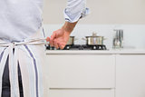 Mid section of a man wearing apron in kitchen