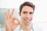 Close up of a smiling man gesturing okay sign