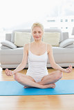Toned woman in lotus pose at fitness studio