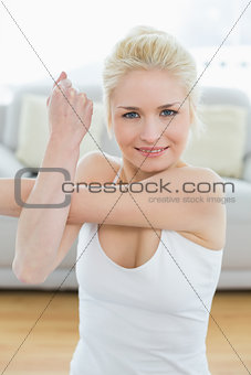 Sporty woman stretching hand in fitness studio