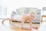 Sporty woman doing push ups in fitness studio