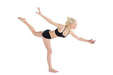 Sporty young woman balancing on one leg