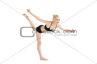Sporty young woman balancing on one leg