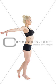Full length of a sporty young woman stretching out hands