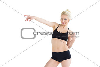 Beautiful sporty young woman pointing away