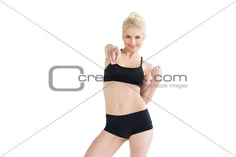 Sporty young woman pointing towards the camera