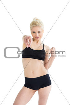 Sporty young woman pointing towards the camera