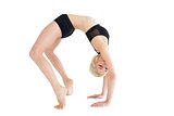 Side view of a fit young woman doing the wheel pose