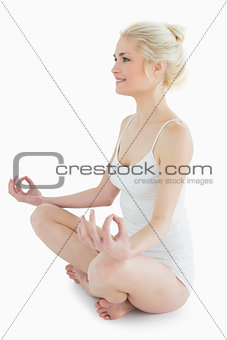 Full length of toned woman sitting in lotus position