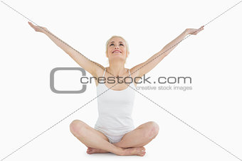 Toned young woman sitting with arms outstretched