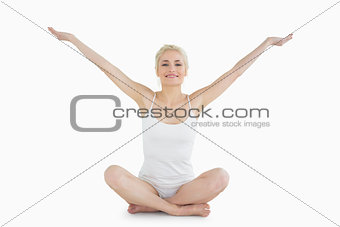 Toned young woman sitting with arms outstretched