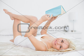 Portrait of relaxed woman reading a book in bed