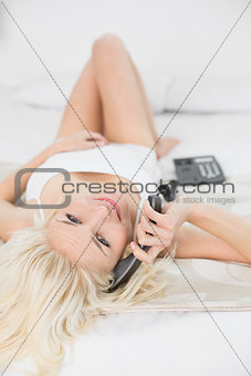 Portrait of relaxed woman using telephone in bed