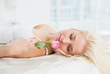 Close up of a pretty woman in bed with a rose