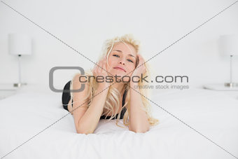 Portrait of a serious blond lying in bed