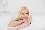 Portrait of smiling beautiful blond lying in bed