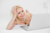 Casual relaxed blond with laptop in bed