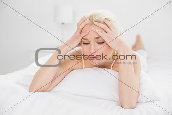 Tensed pretty woman lying in bed