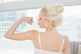 Rear view of fit woman flexing muscles in fitness studio