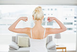 Rear view of woman flexing muscles in fitness studio