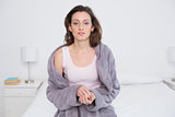 Beautiful young woman in bathrobe sitting in bed
