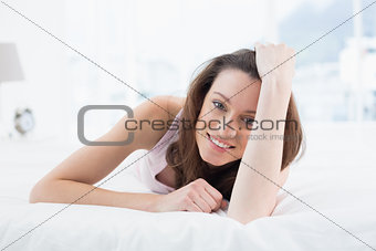 Close up portrait of pretty happy woman resting in bed