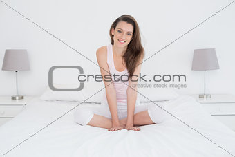Beautiful casual young woman sitting in bed