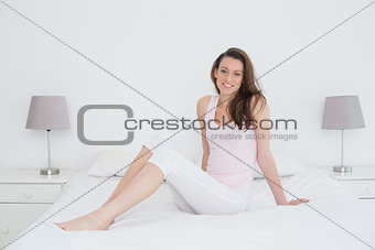 Beautiful casual young woman sitting in bed
