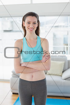 Toned woman with hands folded in fitness studio