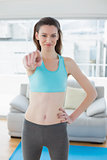 Toned woman pointing at the camera in fitness studio