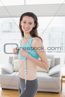 Woman in sportswear measuring chest in fitness studio
