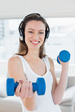 Fit woman exercising with dumbbells in fitness studio