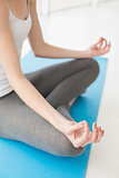 Toned woman sitting in lotus pose at fitness studio