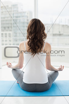Rear view of a toned woman sitting in lotus pose
