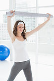 Fit woman holding up towel in a fitness studio
